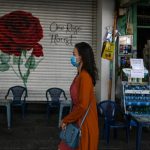 A woman walks past a closed shop along a street in Ho Chi Minh City on June 27, 2020 (AFP)