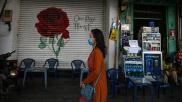A woman walks past a closed shop along a street in Ho Chi Minh City on June 27, 2020 (AFP)