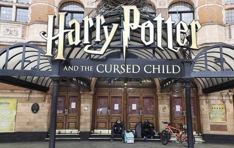 Food delivery riders sit on the steps of a closed theatre in central London, Thursday, March 19, 2020, after theatres in London are closed for the foreseeable future.Kirsty Wigglesworth/AP