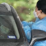 A healthcare professional, right, takes a sample from a patient at a United Memorial Medical Center COVID-19 testing site Wednesday, June 24, 2020 - Copyright David J. Phillip/AP Photo