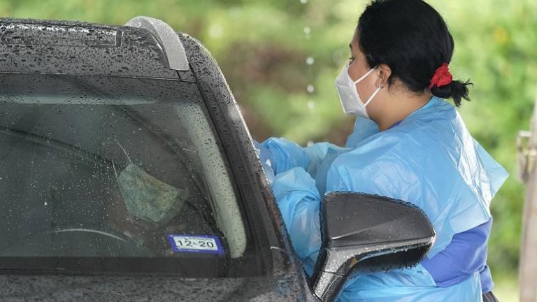 A healthcare professional, right, takes a sample from a patient at a United Memorial Medical Center COVID-19 testing site Wednesday, June 24, 2020 - Copyright David J. Phillip/AP Photo