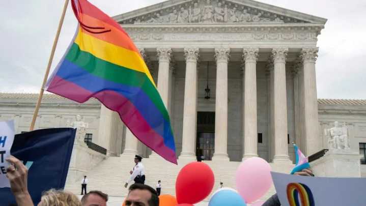 LGBT supporters wave their flag in front of the U.S. Supreme Court on Oct. 8, 2019, in Washington, when the court heard arguments on LGBT rights cases. (Manuel Balce Ceneta/The Associated Press)